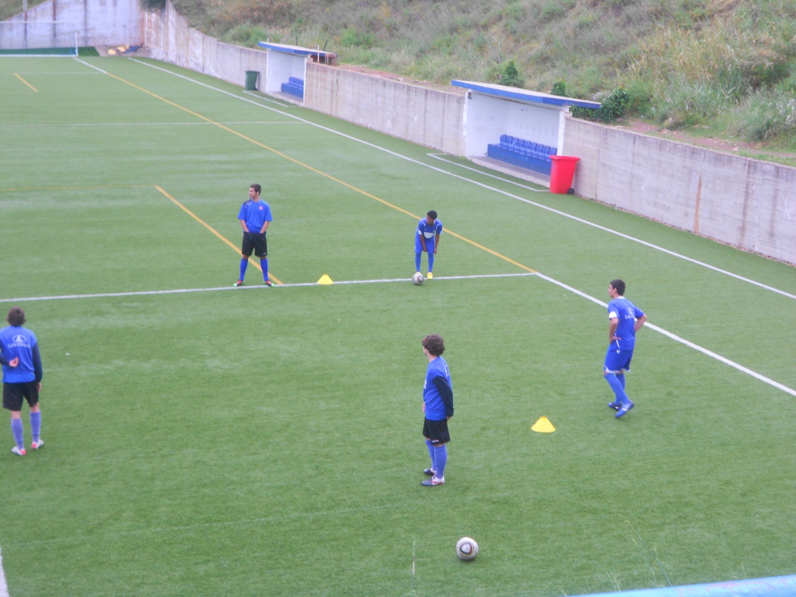 Exercício técnico com cones no campo principal